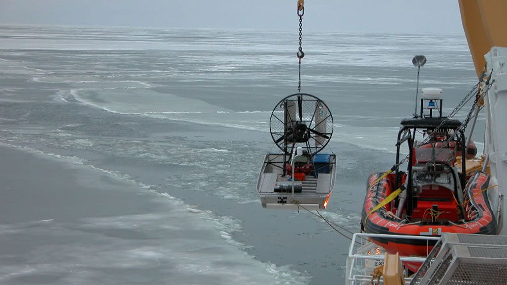 The Amundsen lowering a small boat into an area of thin sea ice in the Arctic Ocean